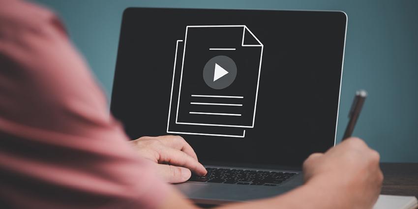 The image shows a person working on a laptop displaying a document icon with a play button